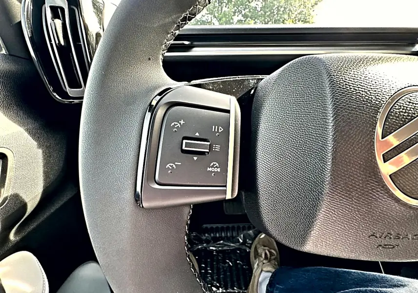 Gros plan sur la partie gauche du volant noir de la Citroën C3 Aircross 2026, avec commandes multifonctions visibles.