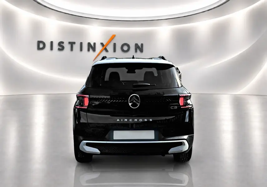 Vue arrière d'un Citroën C3 Aircross noir 2026 avec feux LED et barres de toit visibles dans un showroom lumineux.