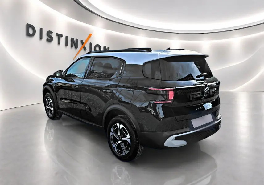 Vue 3/4 arrière droite d'un Citroën C3 Aircross noir avec toit argenté et jantes alu distinctives.