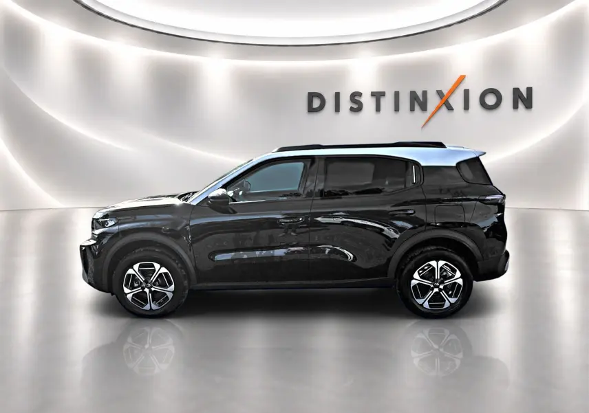 Profil droit d'un Citroën C3 Aircross noir 2026 avec jantes alu et barres de toit, sur fond lumineux avec logo Distinxion.