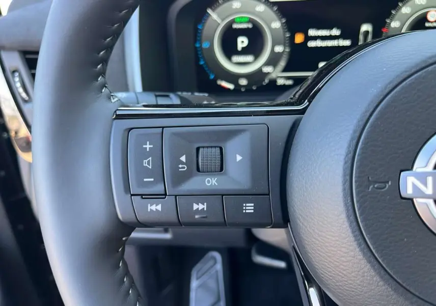 Gros plan sur la partie gauche du volant cuir multifonctions du Nissan Qashqai E-POWER 2026 avec commandes intégrées.