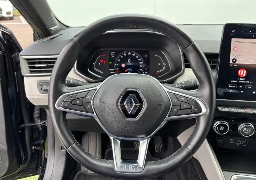 Volant cuir Renault Clio Initiale Paris noir étoilé vu de face, avec tableau de bord numérique et écran tactile central.