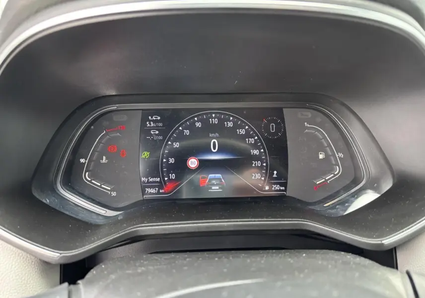 Tableau de bord numérique de Renault Clio 2020, affichage vitesse et alertes, vue frontale rapprochée.