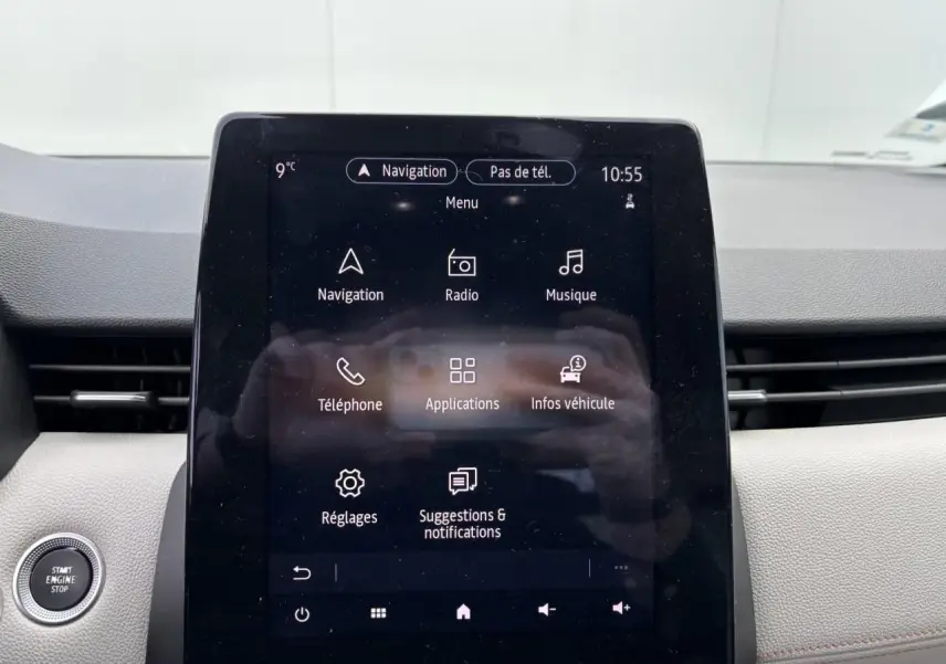 Écran tactile central du tableau de bord de la Renault Clio noire étoile, affichant le menu de navigation et applications.