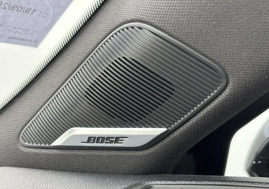 Gros plan sur l'enceinte Bose intégrée côté gauche de l'habitacle d'une Renault Clio noire étoile 2020.