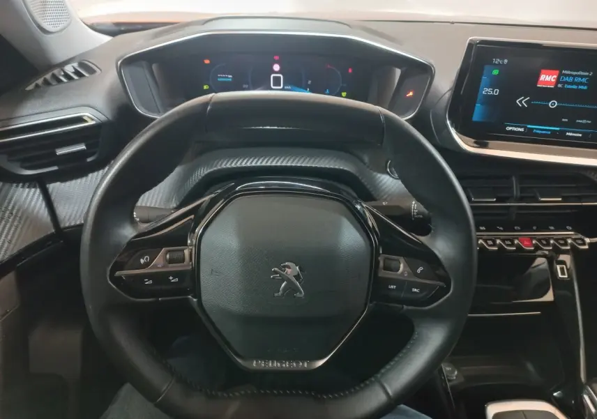 Vue intérieure centrée sur le volant cuir noir du Peugeot 2008 2021 avec tableau de bord numérique et écran tactile.