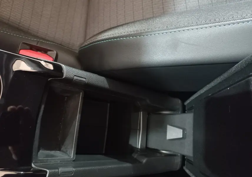Vue rapprochée de la console centrale noire et du siège avant gris du Peugeot 2008 Orange 2021.