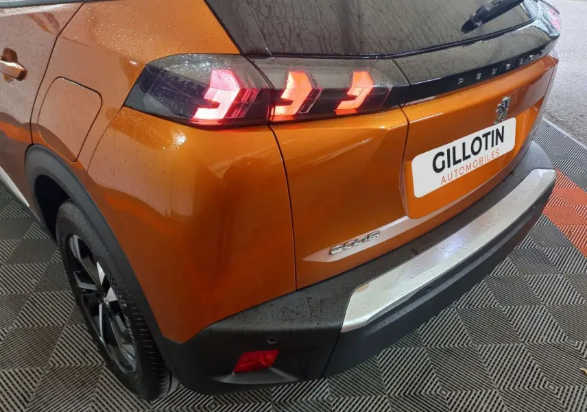 Vue 3/4 arrière droite du Peugeot 2008 orange avec feux arrière LED et logo visible sur le hayon