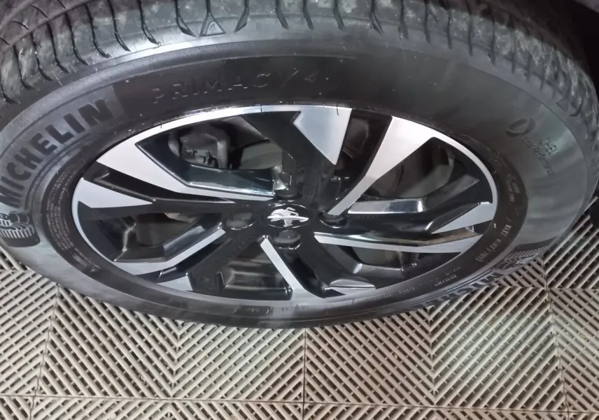 Gros plan sur la roue avant droite de la Peugeot 2008 orange, jante alliage noir et argent avec pneu Michelin.