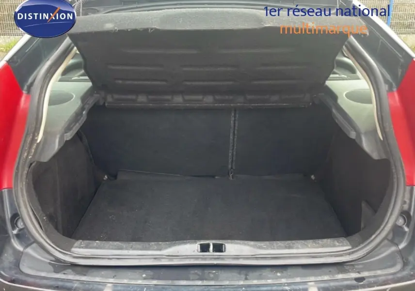 Coffre ouvert d'une Citroën C4 Coupé noir métal 3 portes, vue arrière centrée montrant l'espace de chargement vide.