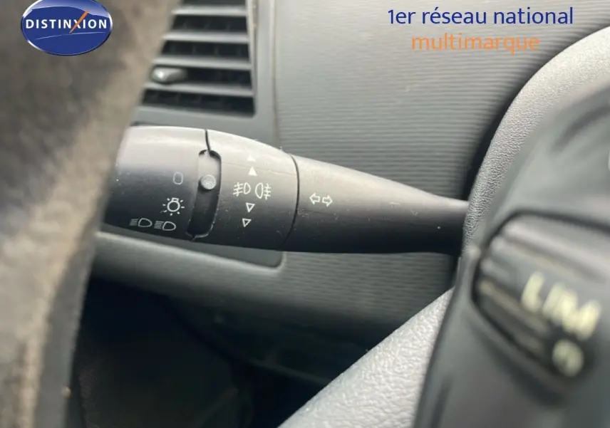 Gros plan sur la manette de clignotants à gauche du volant dans l’habitacle d’une Citroën C4 Coupe noir métal de 2009.