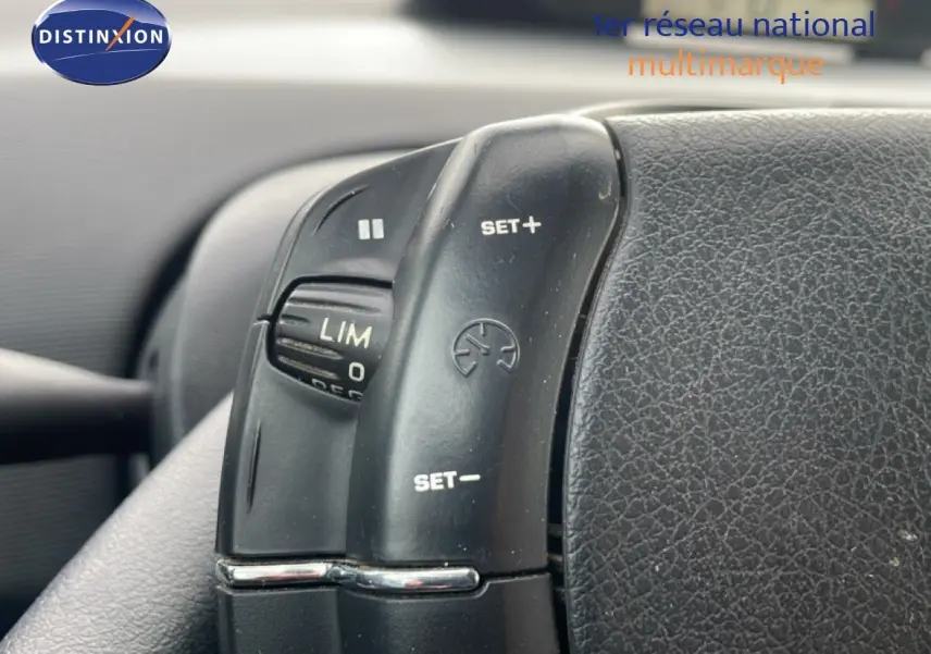 Gros plan sur les commandes de régulateur de vitesse au volant d’une Citroën C4 Coupé noir métal de 2009.