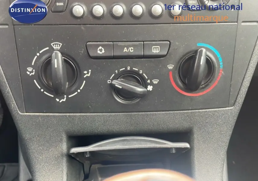 Vue rapprochée du tableau de bord et des commandes de climatisation d'une Citroën C4 Coupe noire de 2009.