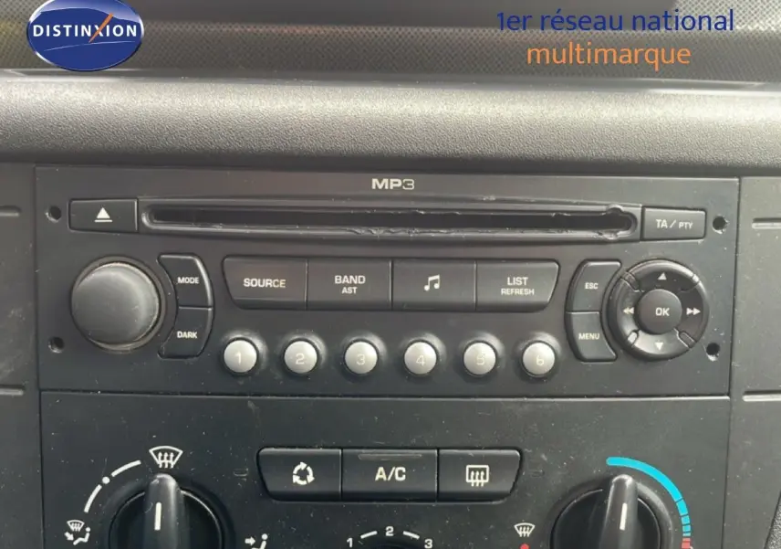 Vue rapprochée du tableau de bord de la Citroën C4 2009, montrant la radio MP3 et les commandes de climatisation.