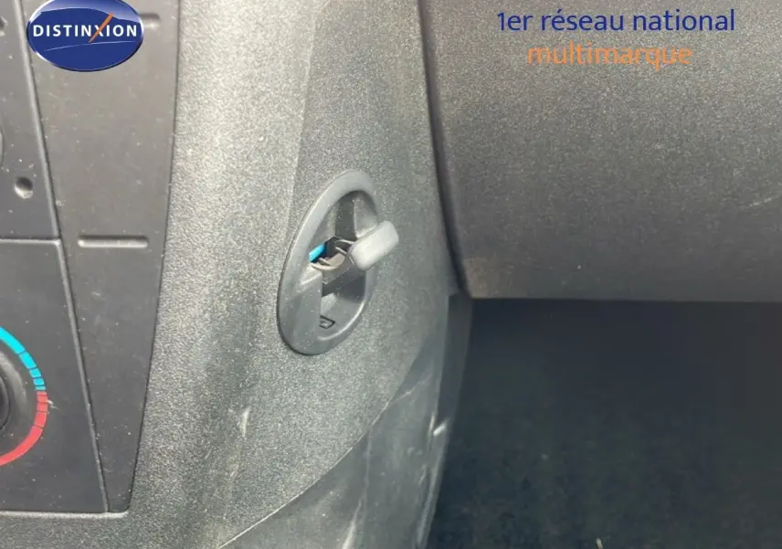 Détail intérieur montrant la commande d'ouverture de la boîte à gants sur une Citroën C4 Coupé noir métal de 2009.
