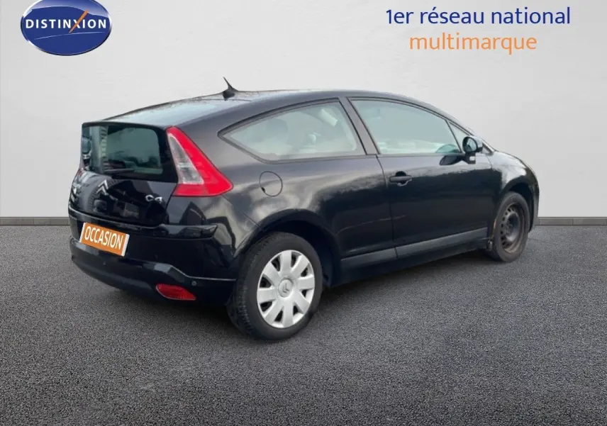 Vue 3/4 arrière droite d'une Citroën C4 Coupé noire métal de 2009 avec jantes acier et feux arrière distinctifs.