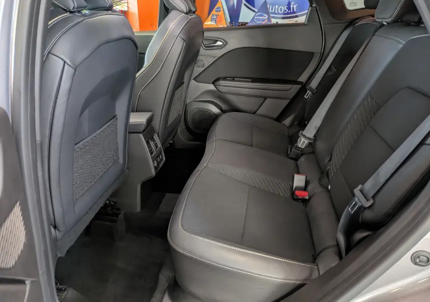Vue intérieure côté droit sur la banquette arrière noire avec surpiqûres contrastantes du Renault Symbioz 2025 gris cassiopée.