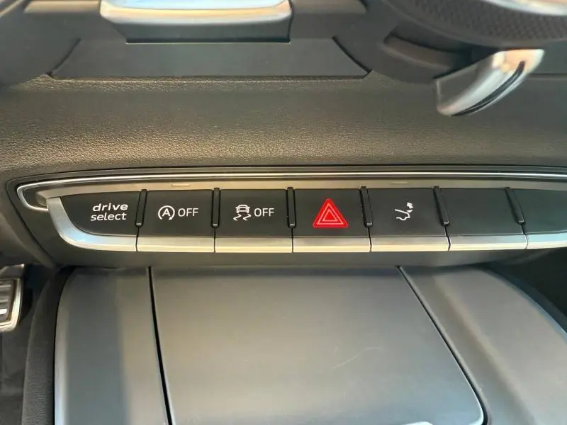 Gros plan sur la rangée de boutons de commande noirs et argentés du tableau de bord de l'Audi TT Coupé 2016.