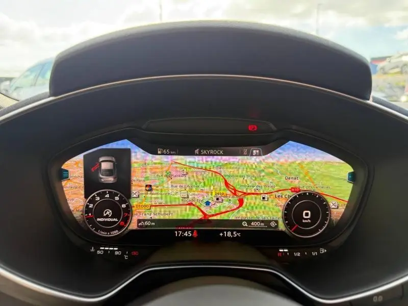 Vue rapprochée du tableau de bord numérique de l'Audi TT Coupé 2016 avec affichage GPS coloré et compte-tours digital.