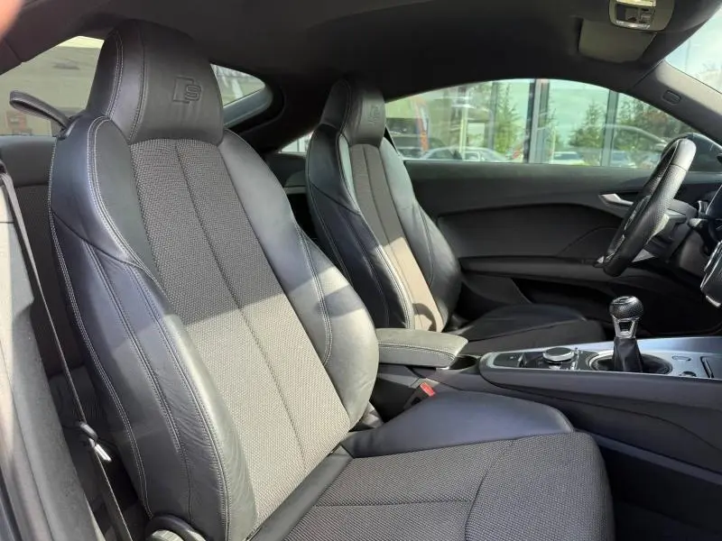 Vue intérieure côté droit de l’Audi TT Coupé 2016, sièges sport cuir/tissu noirs avec logo S embossé.