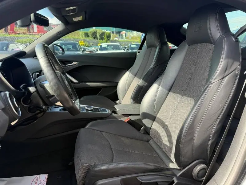 Vue intérieure côté conducteur de l'Audi TT Coupé 2016, sièges sport cuir/tissu noirs avec logo S embossé.