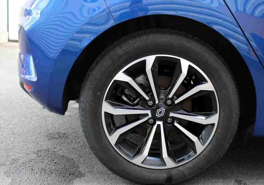 Gros plan sur la roue avant gauche de la Renault Clio bleu iron metal, mettant en valeur la jante alliage au design moderne.