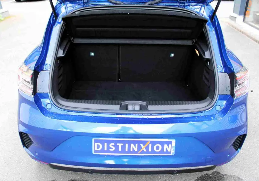 Coffre ouvert vu de l'arrière d'une Renault Clio 2025 bleu iron metal, montrant l'espace de chargement vide.