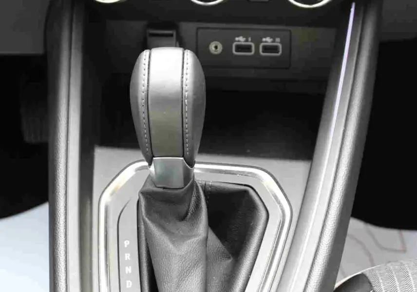 Gros plan sur la console centrale de la Renault Clio hybride 2025, montrant le levier de vitesse automatique et les commandes de climatisation.