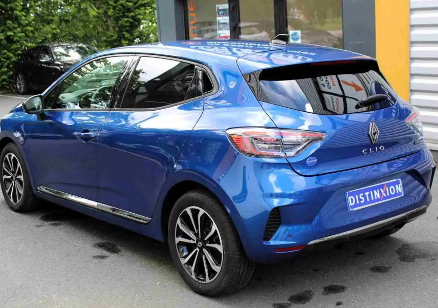 Vue 3/4 arrière droite d'une Renault Clio 2025 bleu iron metal avec jantes alliage et vitres teintées.