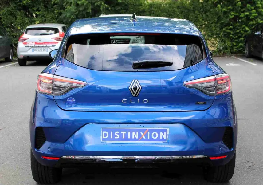 Vue arrière d'une Renault Clio bleu iron metal 2025 avec logo distinctif et plaque d'immatriculation Distinxion.