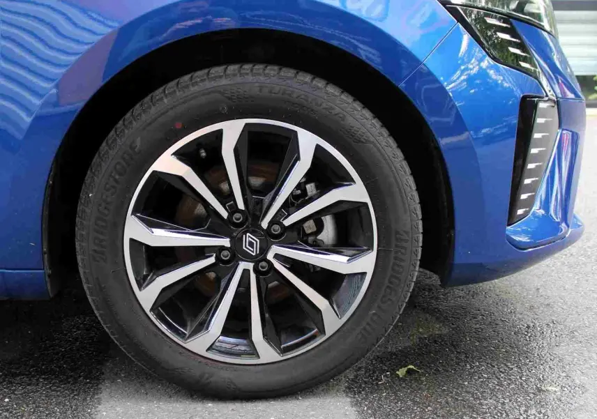 Gros plan sur la roue avant droite de la Renault Clio bleu iron metal avec jante alliage au design moderne.