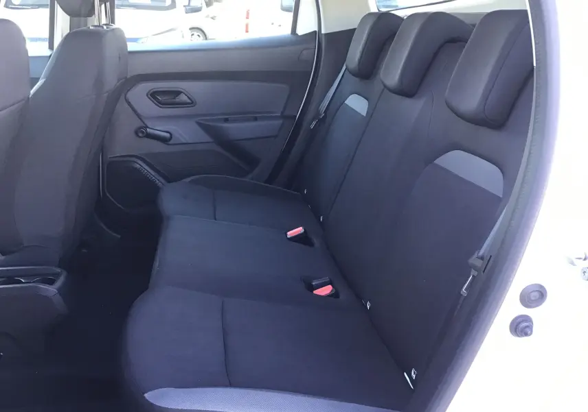 Vue intérieure côté droit des sièges arrière noirs du Dacia Duster blanc 2021, avec appuie-têtes et ceinture visible.