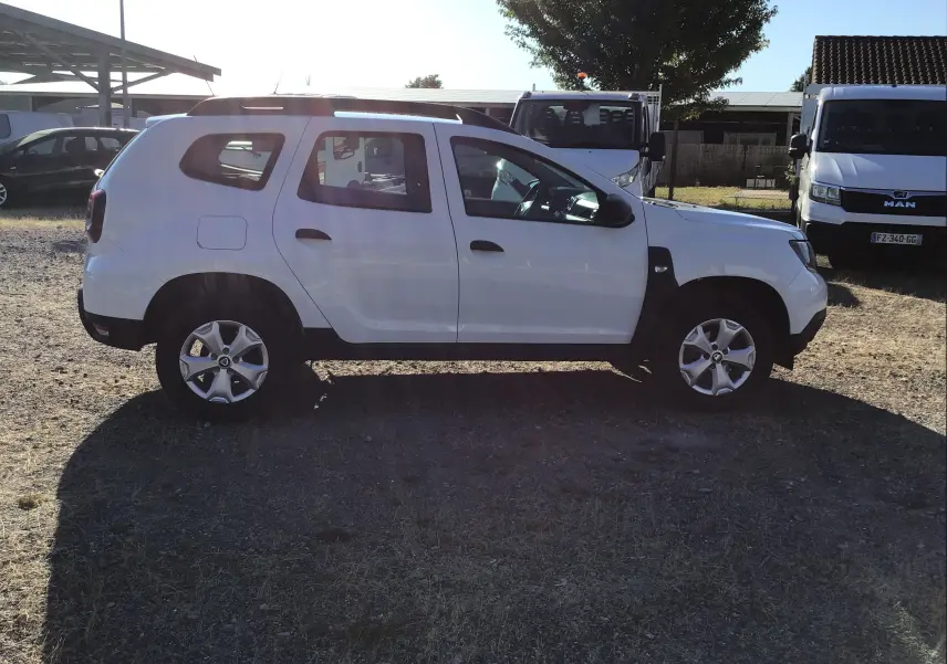 Profil latéral gauche d'un Dacia Duster blanc 2021, version 4x2 ECO-G, avec jantes alliage et carrosserie sobre.