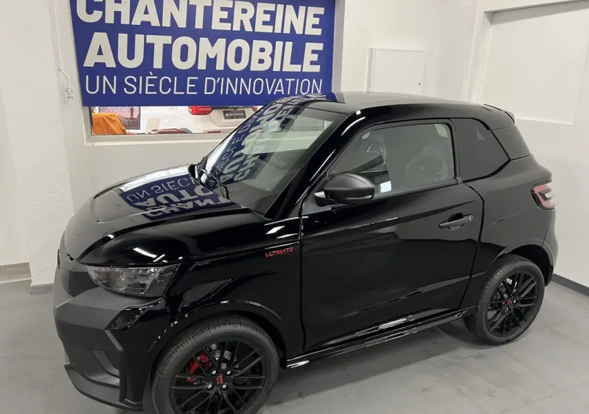 Vue 3/4 avant droite d'une LIGIER JS50 noire mate avec jantes alu noires et badge Ultimate sur l'aile avant.