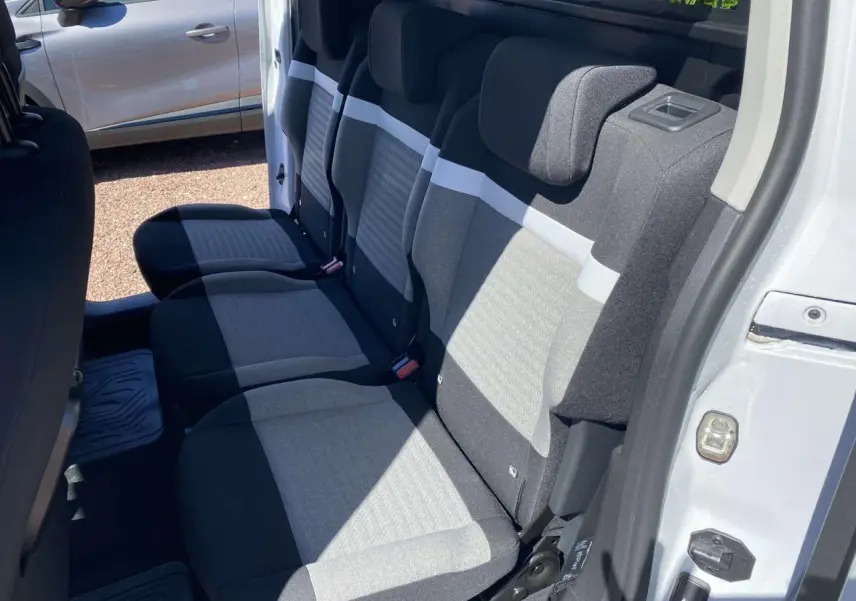 Vue intérieure côté droit sur la banquette arrière grise et noire du Citroën Berlingo blanc 2025 avec porte coulissante ouverte.