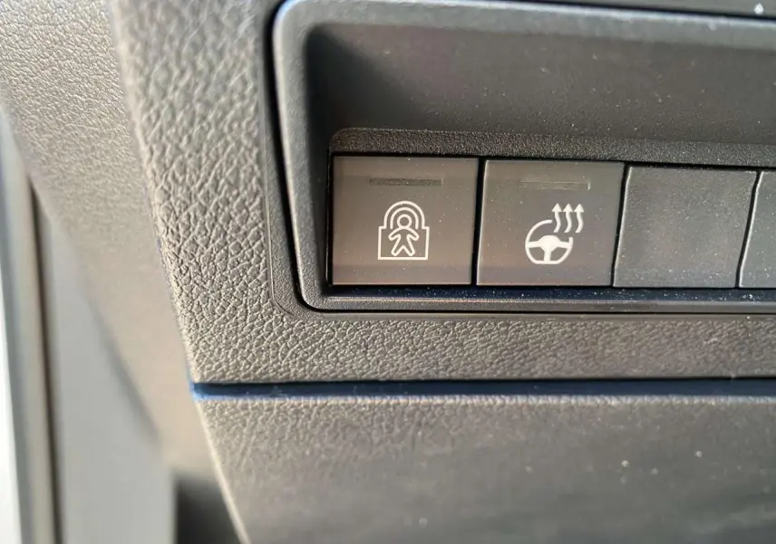 Boutons de commande du tableau de bord du Citroën Berlingo 2025, vue rapprochée sur les fonctions de sécurité et de chauffage du volant.