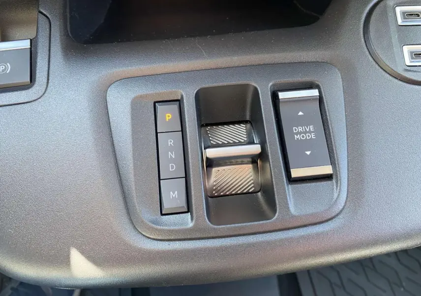Gros plan sur la console centrale noire du Citroën Berlingo 2025, avec commandes de boîte auto et mode de conduite.