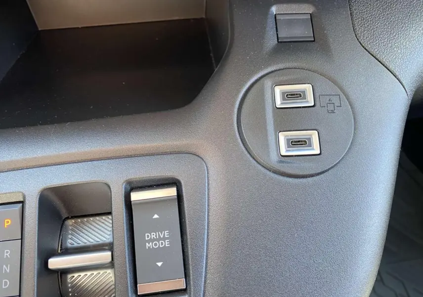 Gros plan sur la console centrale noire du Citroën Berlingo 2025 avec boutons Drive Mode et deux ports USB-C.