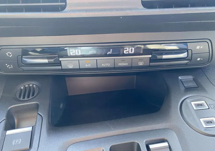 Détail de la console centrale du Citroën Berlingo 2025, montrant la climatisation automatique et le frein de stationnement électrique.