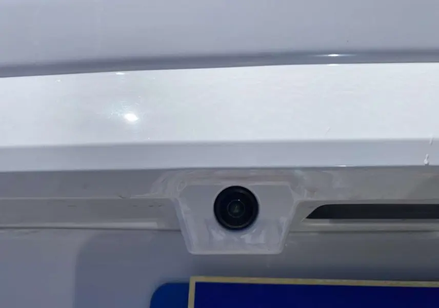 Gros plan sur la caméra de recul intégrée au hayon blanc du Citroën Berlingo 2025, version diesel automatique.