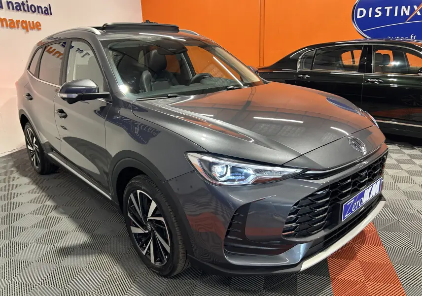 Vue 3/4 avant d’un MG ZS Hybrid+ 197 Luxury gris Candem avec toit panoramique et jantes alliage noires.