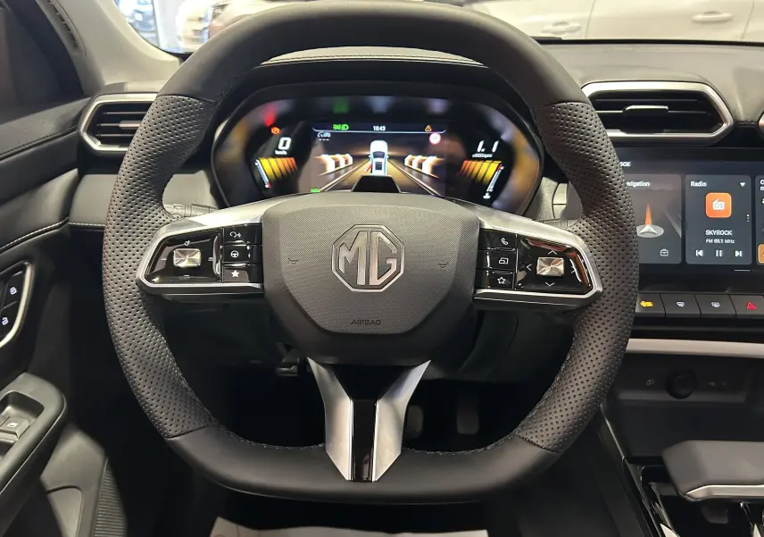 Vue frontale du volant en cuir perforé de la MG ZS Hybrid+ 197 Luxury avec tableau de bord numérique et écran tactile central.