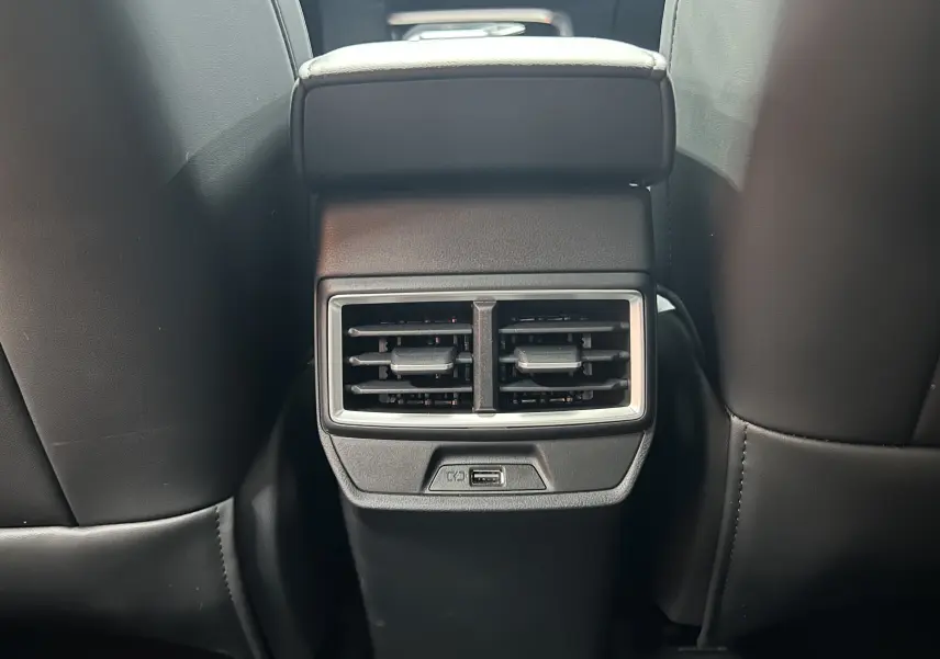 Vue rapprochée des aérateurs arrière et port USB entre les sièges avant en cuir noir du MG MOTOR ZS Hybrid+ 2026.