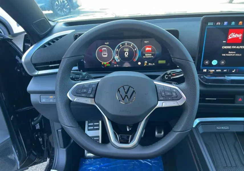 Vue intérieure centrée sur le volant cuir multifonctions du Volkswagen T-Roc 2026 avec tableau de bord digital et écran tactile.