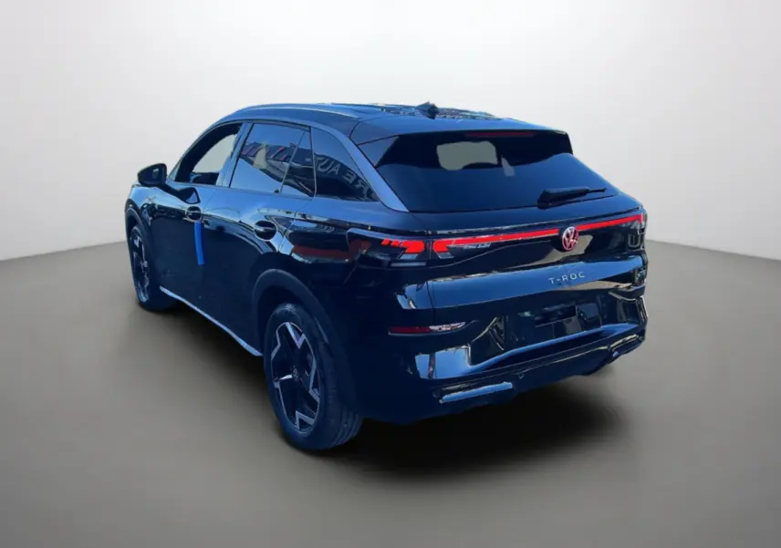 Vue 3/4 arrière droite du Volkswagen T-Roc noir ebène avec feux arrière LED et jantes alu 18 pouces noires.