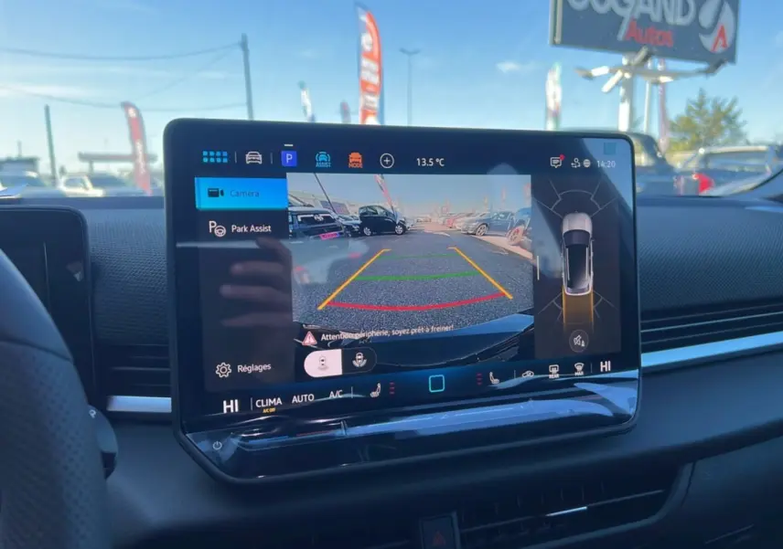 Écran central tactile du Volkswagen T-Roc noir ebène 2026 montrant la caméra de recul et l'assistance au stationnement.