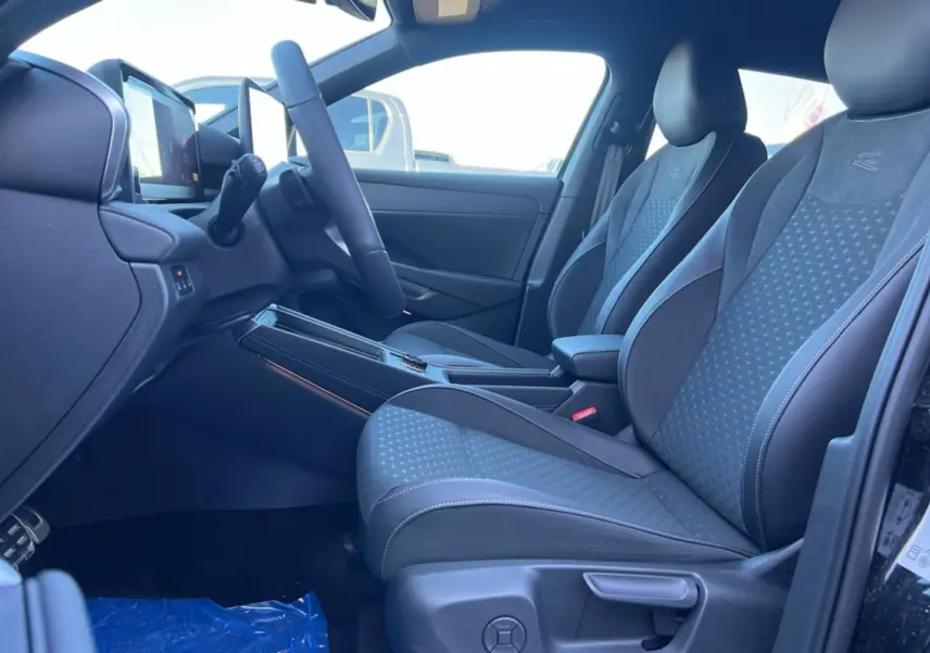 Vue intérieure côté conducteur du Volkswagen T-Roc 2026 R-Line avec sièges tissu noirs et volant cuir multifonctions.