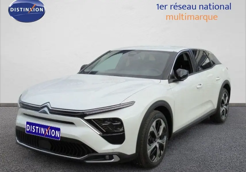 Vue 3/4 avant droit d'une Citroën C5 X blanche métallisée avec jantes bi-ton et calandre moderne.