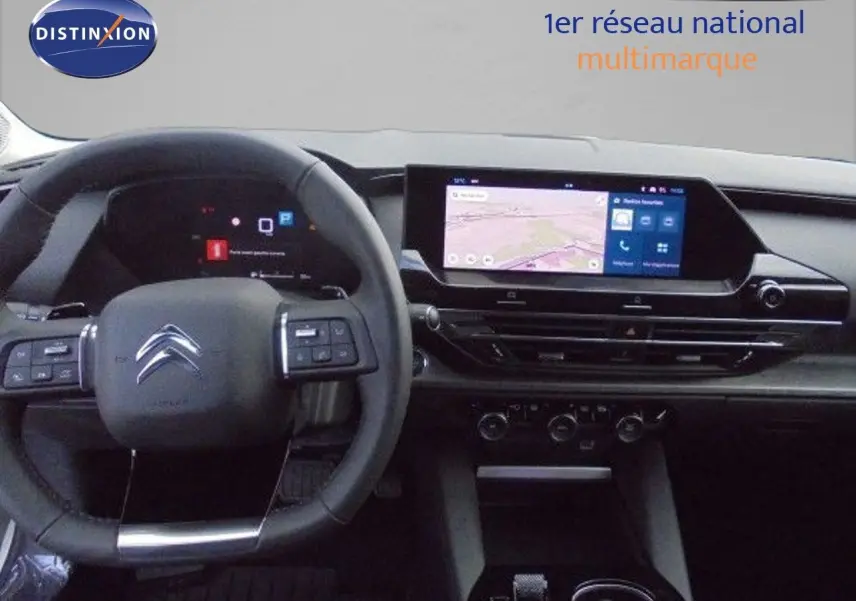 Vue intérieure du tableau de bord et volant noir du Citroën C5 X 2023 avec écran tactile central et commandes au volant.