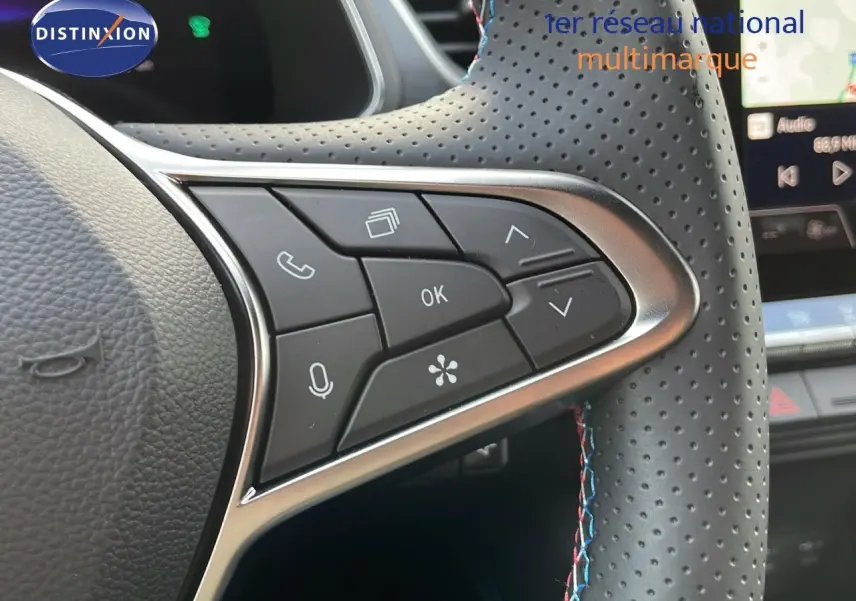 Gros plan sur le volant en cuir perforé noir avec surpiqûres tricolores du Renault Captur E-Tech hybride 2025.